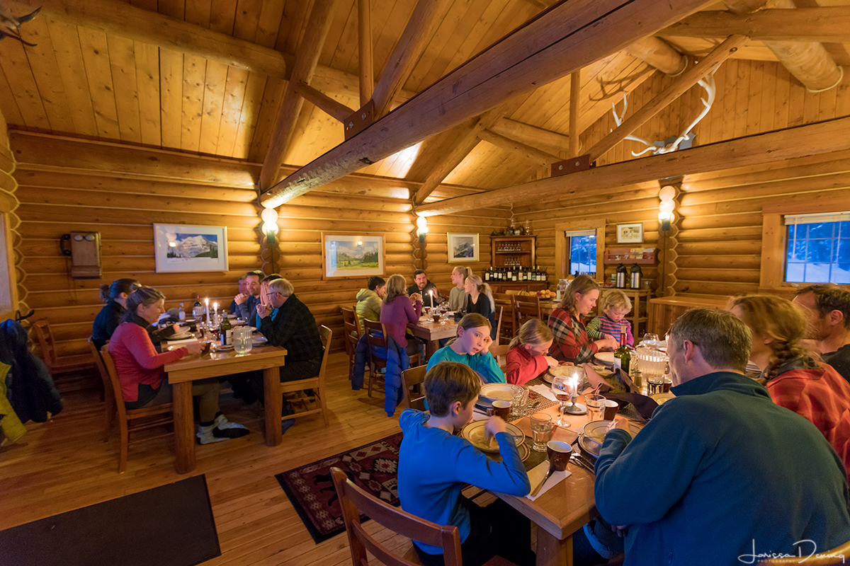 Enjoying good conversation and great food in the dining cabin at Shadow Lake Lodge, Banff